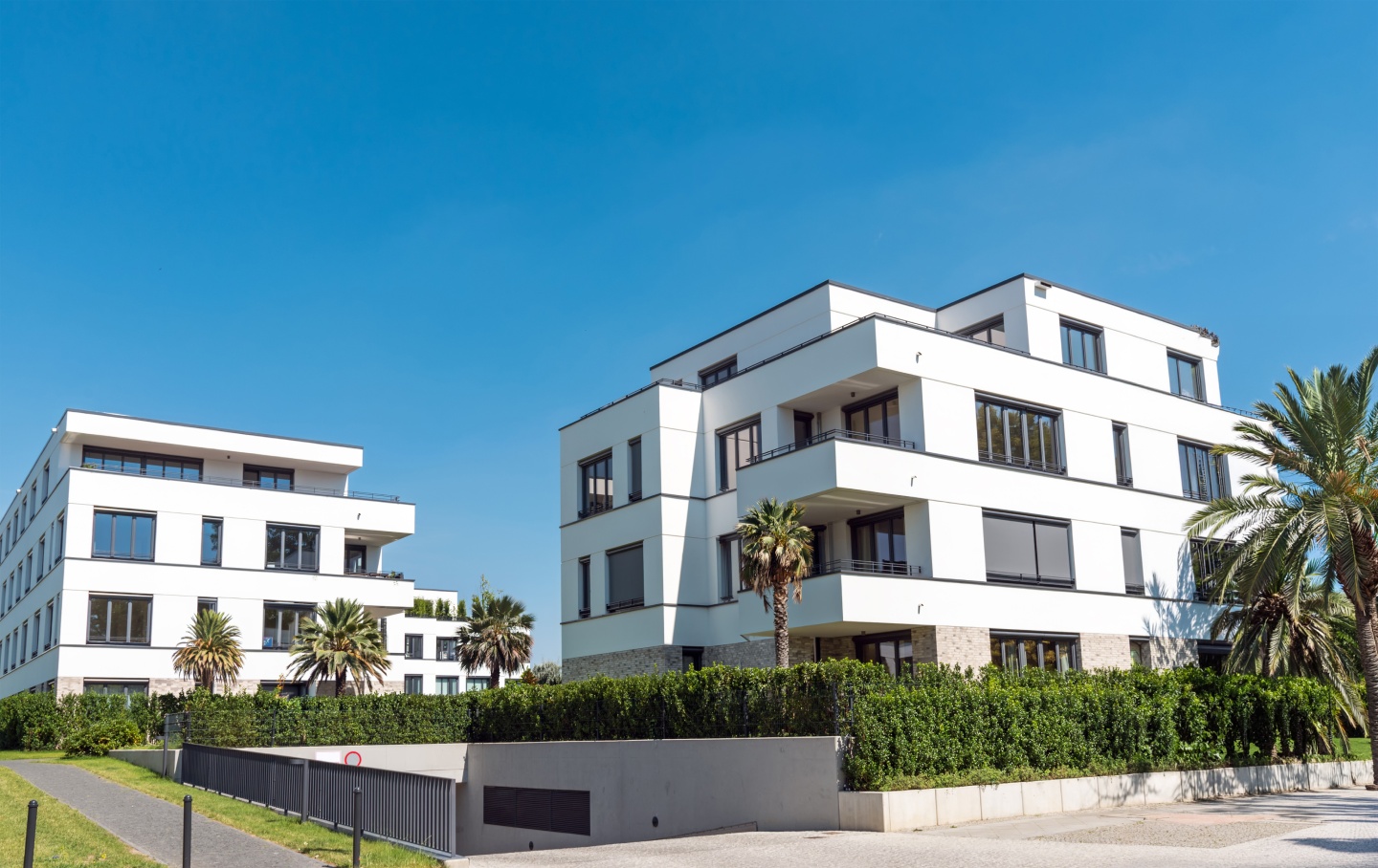 Résidences modernes blanches entourées de palmiers à La Réunion, biens concernés par le diagnostic immobilier